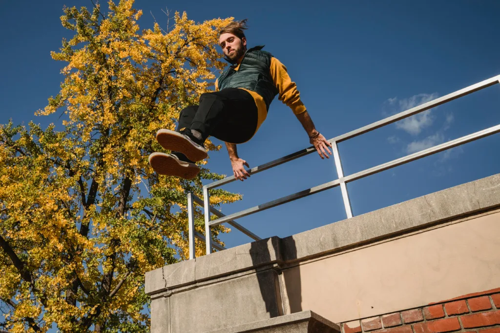 Ein Parkourläufer springt von einem Geländer herunter